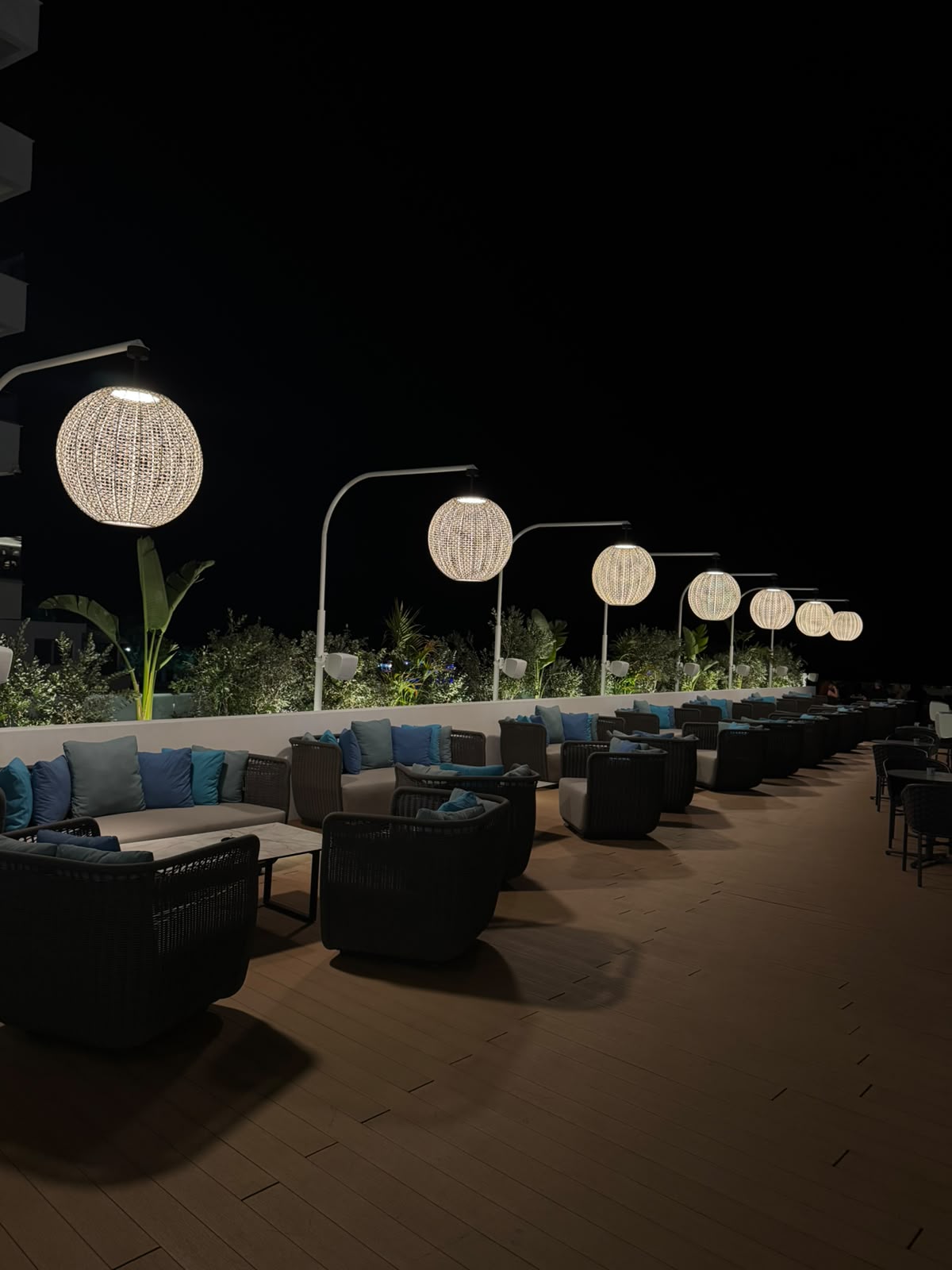 The Cosmos terrace on Flamingo Paradise Beach after dark, lit by woven rattan globes